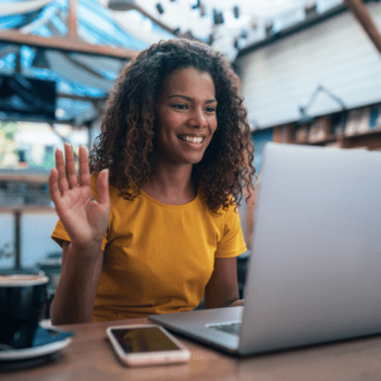 woman taking Spanish class on computer waving