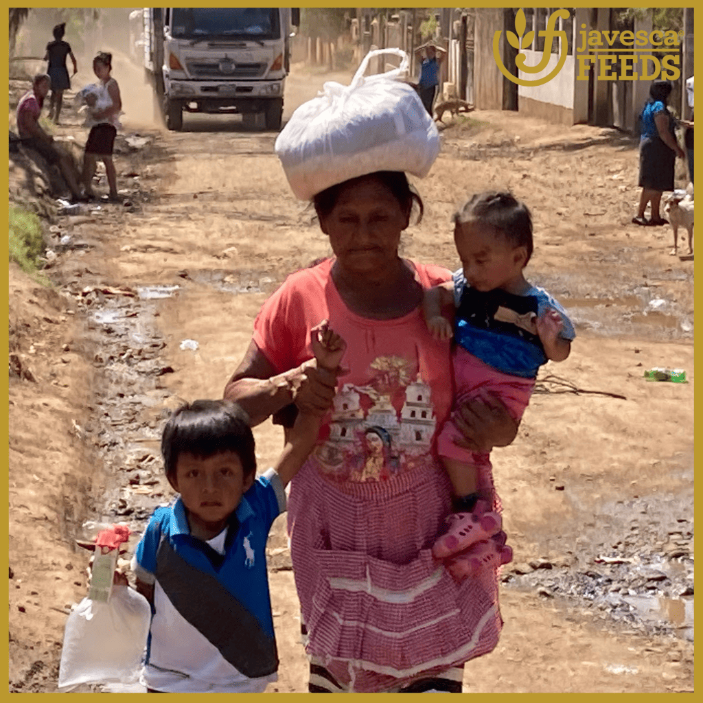 woman carrying a food parcel on her head and a baby in Guatemala.